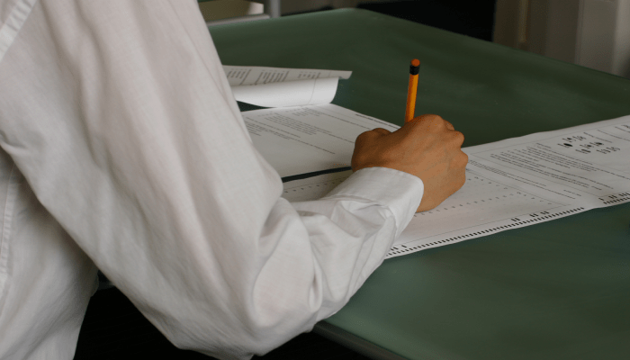 القبول المركزي في العراق 2026-2027.. 50 رغبة للعلمي و25 للأدبي وآخر موعد للتقديم 1 Hand writing exam classroom