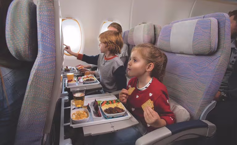 caucasian family enjoying means on a380 economy class w768x4800